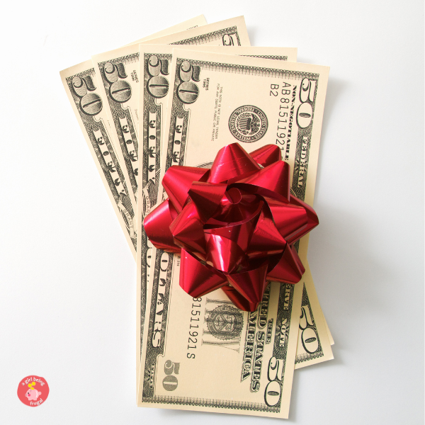 Four fifty dollar bills with a red Christmas bow on top.