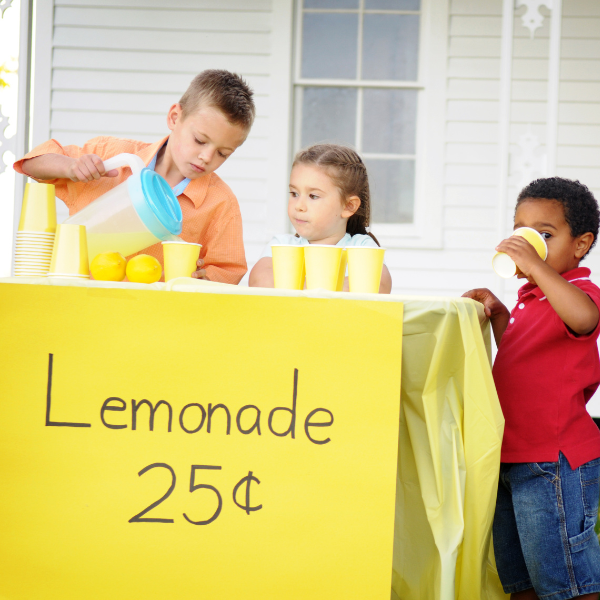 Kids selling lemonade at their lemonade stand.