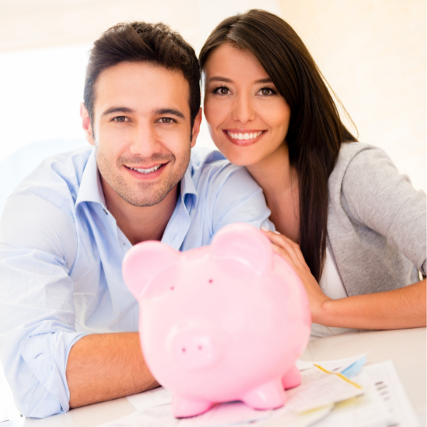 happy couple saving money in a big pink piggy bank.