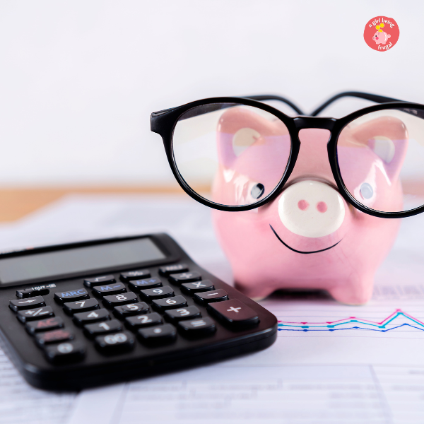 piggy bank with eyeglasses on with a calculator and budget sheet