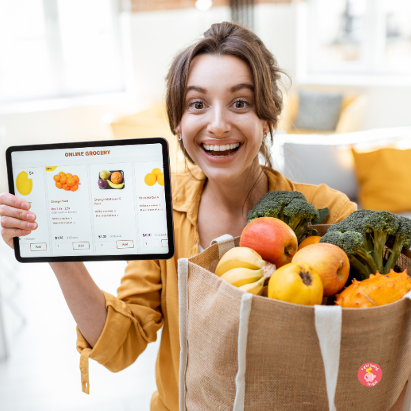 Happy Woman Holding a tablet with online store while standing with a bag of groceries