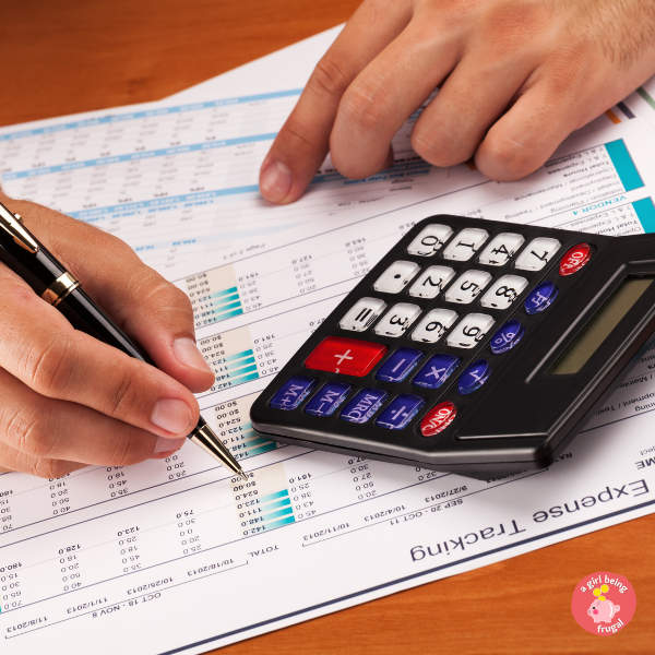 An image of a man's hand, tracking his expenses. A calculator is also seen in the image.